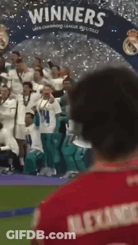 Man In Red Shirt In Front Of Winners Banner GIF