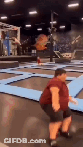 Man In Red Shirt Jumping On Trampoline GIF
