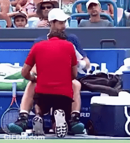 Man In Red Shirt Kneeling On Tennis Court GIF