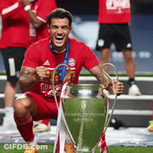 Man In Red Shirt Kneeling With Trophy GIF
