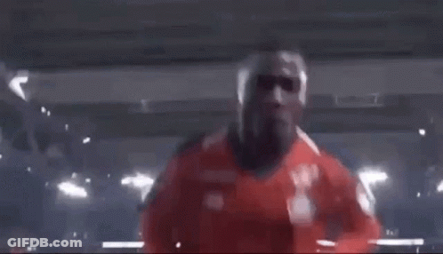 Man In Red Shirt Making Funny Face In Dark Room GIF