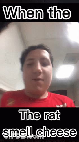 Man In Red Shirt Making Funny Face When Rat Smells Cheese GIF