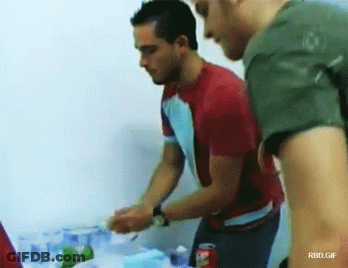Man In Red Shirt Next To Man In Green Shirt With Coca Cola GIF