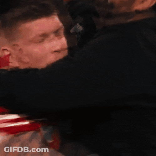 Man In Red Shirt Number 3 Hugged By Another Man GIF