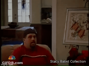 Man In Red Shirt On Couch Beside Stacy Babst Collection Framed Picture GIF