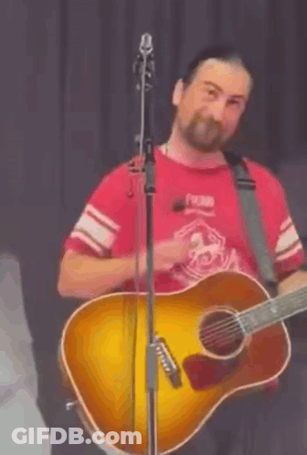 Man In Red Shirt Playing Guitar At Microphone GIF