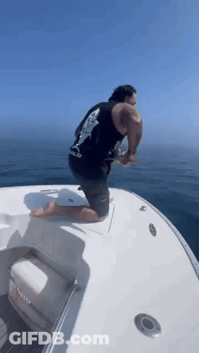 Man In Red Shirt Riding Boat Saying Triathlon GIF