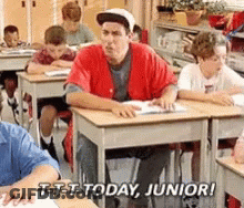 Man In Red Shirt Sitting At Desk In Classroom GIF