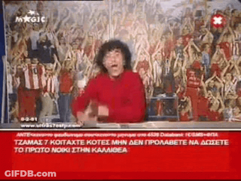 Man In Red Shirt Sitting In Front Of Crowd GIF