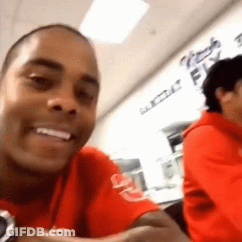 Man In Red Shirt Smiling At Table GIF