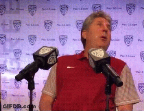 Man In Red Shirt Speaking Into Microphones GIF