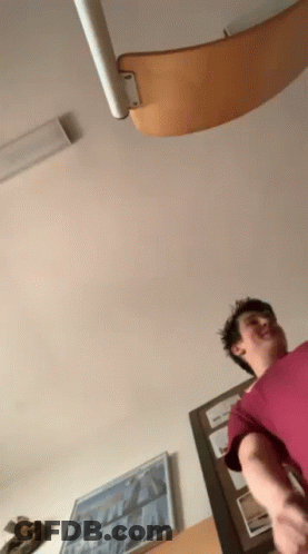 Man In Red Shirt Standing By Staircase GIF