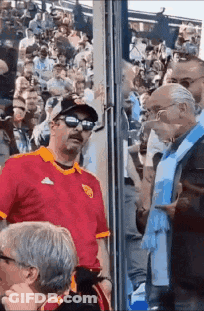 Man In Red Shirt Standing In Crowd GIF