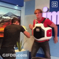 Man In Red Shirt Standing In Front Of Da Zn Sign GIF