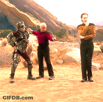 Man In Red Shirt Standing Next To Two Men In Black Pants GIF
