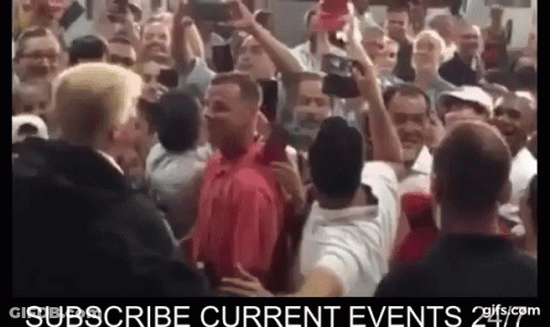 Man In Red Shirt Surrounded By Crowd GIF