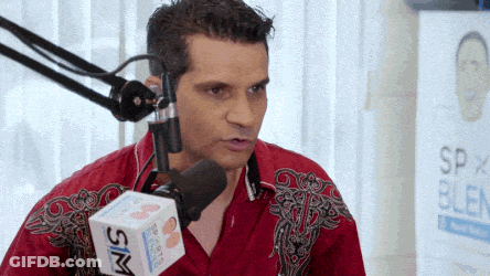 Man In Red Shirt Talking Into Microphone With Sim Box GIF