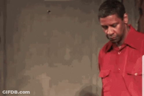 Man In Red Shirt Talking To Another Man In Dark Room GIF