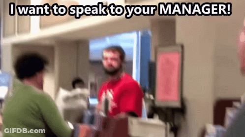 Man In Red Shirt Talking To Woman In Green Sweater Saying I Want To Speak To Your Manager GIF
