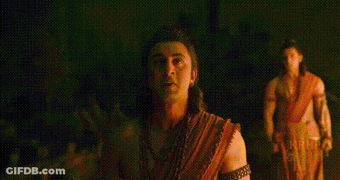Man In Red Shirt Walking Through Green Forest GIF