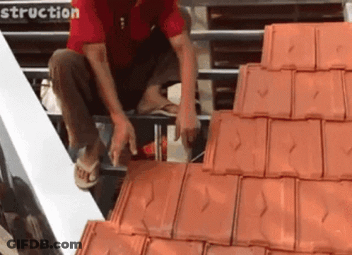 Man In Red Shirt Working On Tiled Roof GIF