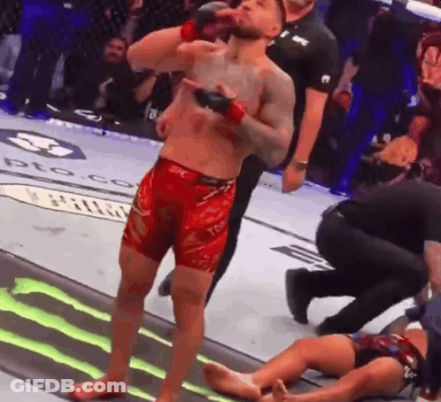 Man In Red Shorts Beside Man In Cage GIF