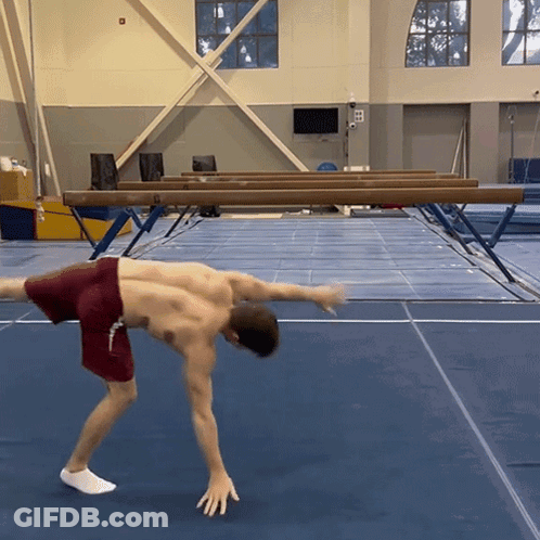 Man In Red Shorts Doing Handstand GIF