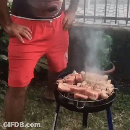 Man In Red Shorts Grilling Meat GIF