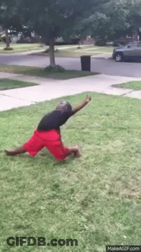 Man In Red Shorts Kneeling On Grass GIF