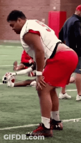 Man In Red Shorts Standing On Football Field Hands On Hips GIF