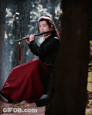 Man In Red Skirt Playing Flute In Forest GIF