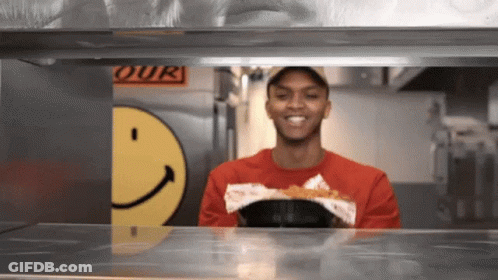 Man In Red Smiley Shirt Smiling At 'Our' Sign GIF
