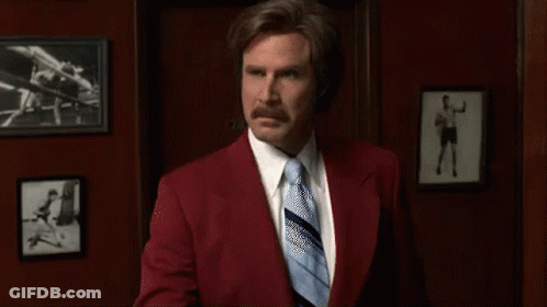 Man In Red Suit And Blue Tie Holding Toothbrush GIF