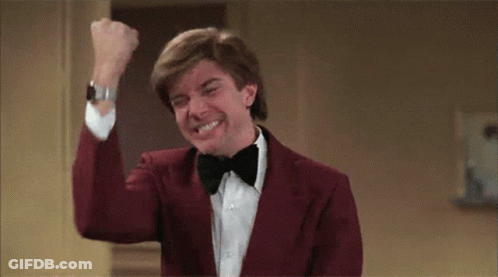 Man In Red Suit And Bow Tie Raising Fist GIF