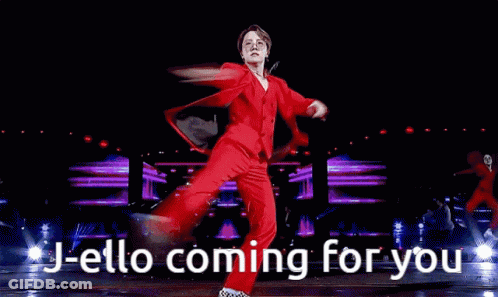 Man In Red Suit And Glasses Holding Microphone Says J-Ello Coming For You GIF