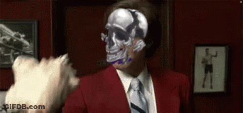 Man In Red Suit And Tie Holding Gun Pointing At Food GIF