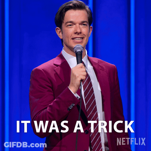 Man In Red Suit And Tie Holding Microphone Saying It Was A Trick GIF