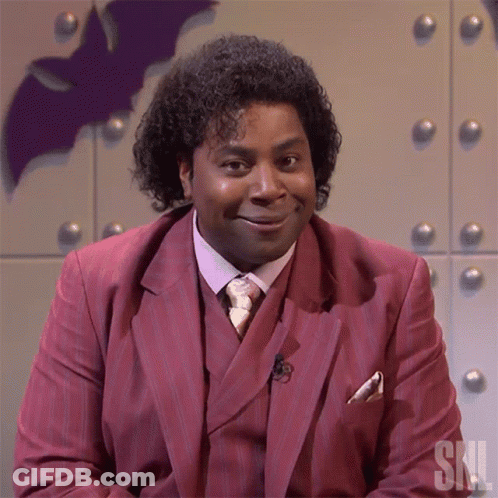Man In Red Suit And Tie With SNL Letters GIF
