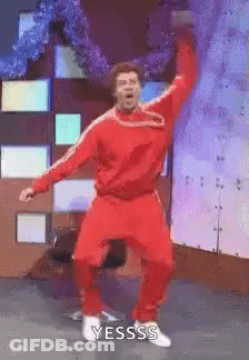 Man In Red Suit Dancing On Stage With Hands In Air GIF