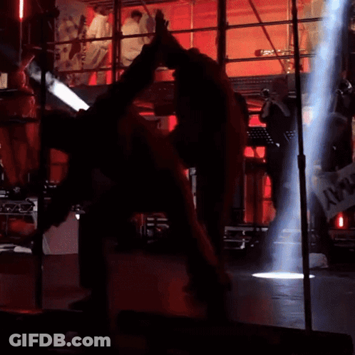 Man In Red Suit Doing Trick On Stage GIF