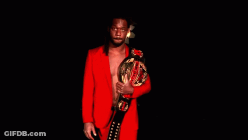 Man In Red Suit Holding Championship Belt GIF