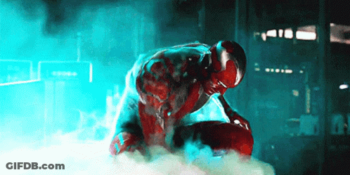 Man In Red Suit Kneeling In Dark Room With Smoke GIF