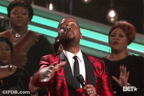 Man In Red Suit Singing Into Microphone In Front Of BET Logo GIF
