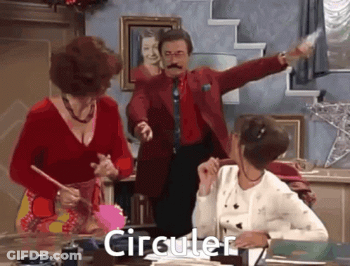 Man In Red Suit Standing Before Two Women Saying Circular GIF
