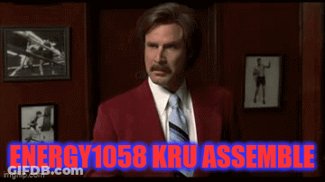 Man In Red Suit Standing In Front Of Energy 1058 Kru Assemble Sign GIF
