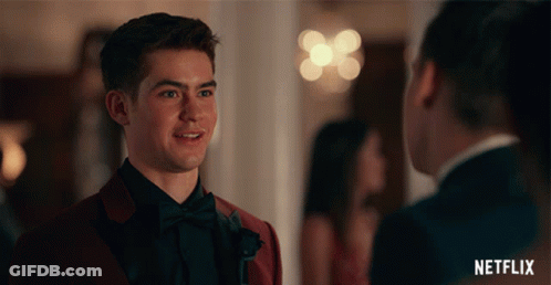 Man In Red Suit Talking To Man In Black Tuxedo GIF