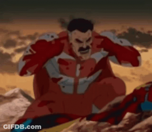 Man In Red Superhero Costume Sitting On Rock Covering Ears GIF