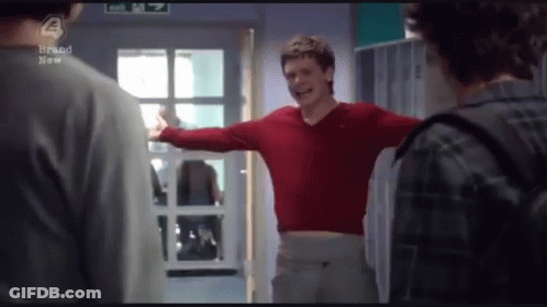 Man In Red Sweater Arms Outstretched In Front Of Exit Sign GIF