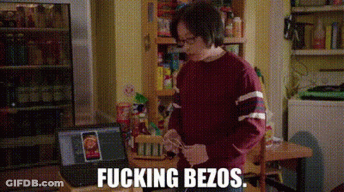 Man In Red Sweater At Table With Laptop And Refrigerator GIF