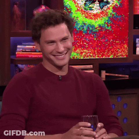 Man In Red Sweater Holding Glass Of Wine Smiling GIF